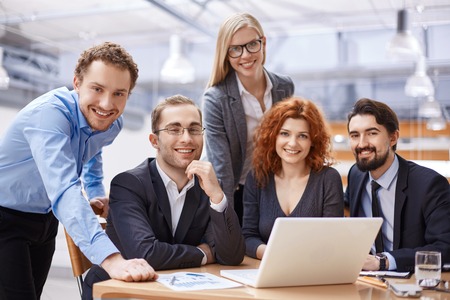 Happy business partners looking at camera with smiles
