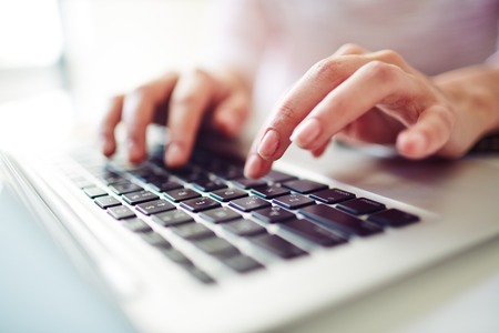 Fingers touching buttons of laptop keypadの写真素材