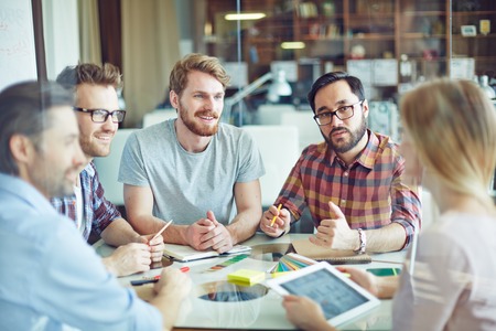 Group of confident managers listening to female employee