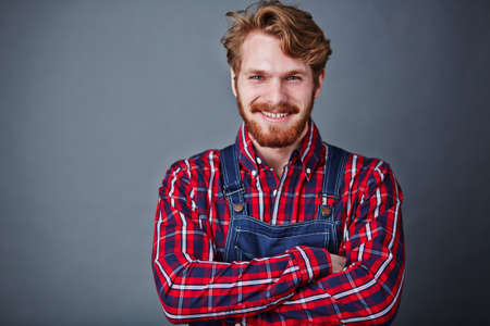 Handsome guy in coveralls looking at camera with smileの写真素材