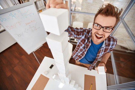 Young designer or architect building high pyramidの写真素材