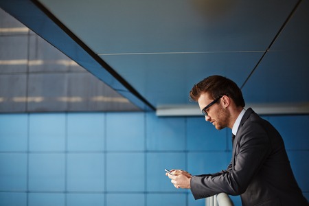 Businessman with cellphone reading or writing smsの写真素材