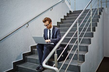 Businessman networking on stairs of office buildingの写真素材
