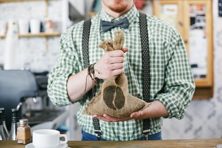 Barista holding sack with coffee grainsの写真素材