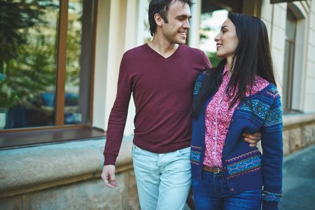 Happy young man embracing his girlfriend during walk