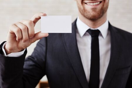 Male employee holding blank visiting cardの写真素材