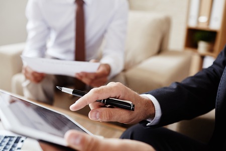 Male employee pointing at screen of digital tabletの写真素材