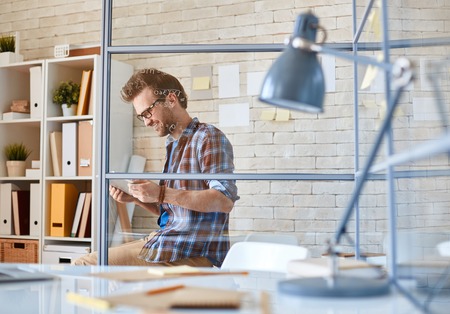 Handsome architect with touchpad working in officeの写真素材