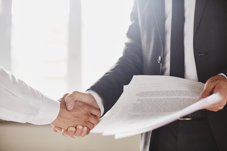 Businessman with documents congratulating his partner