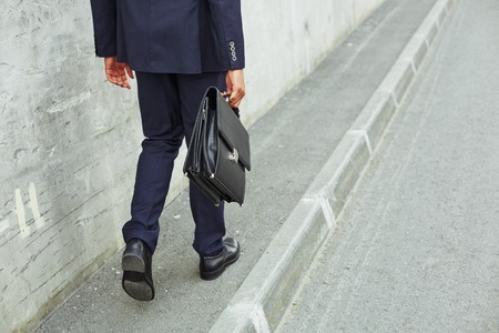 Rear view of businessman legs going to workの写真素材