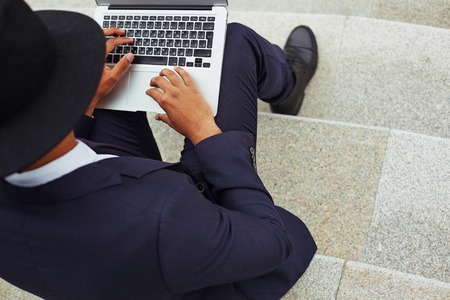 Close-up of businessman using laptop outsideの写真素材