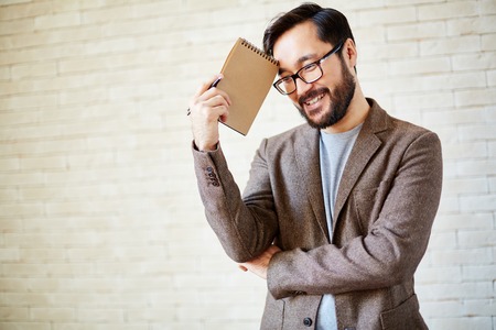 Happy businessman with notepad in isolationの写真素材