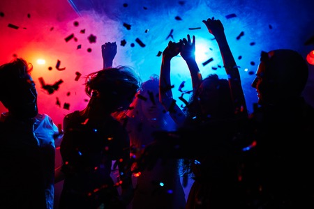 Silhouettes of dancers moving in confettiの写真素材