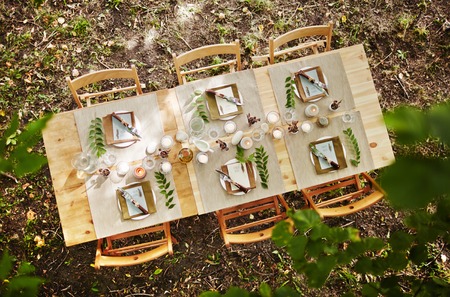 Festive table served for guests with several chairs outdoorsの写真素材