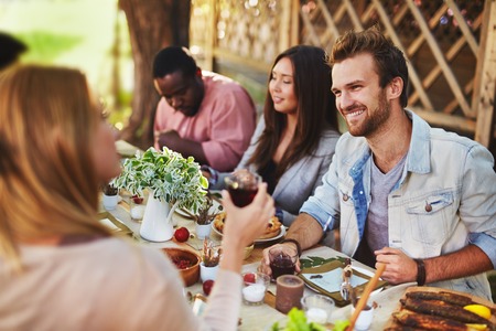 Happy young man talking to girl at Thanksgiving partyの写真素材