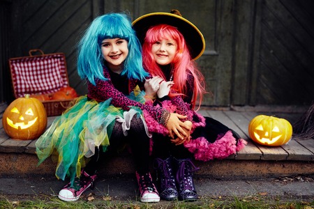 Little friendly girls in Halloween attire looking at cameraの写真素材
