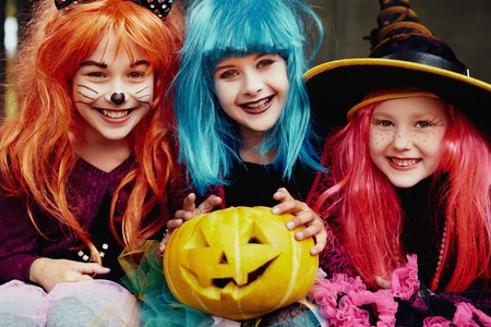 Group of girls in Halloween costumes looking at camera with smilesの写真素材