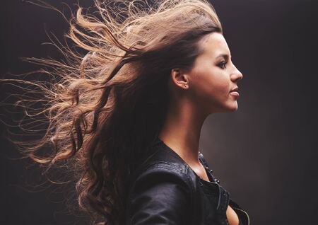 Profile of cool girl with long curly hairの写真素材