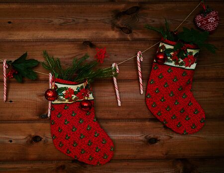Christmas socks, sugar canes, toy bubbles and other decorations on wooden backgroundの写真素材