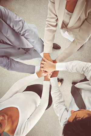 Group of colleagues making pile of hands