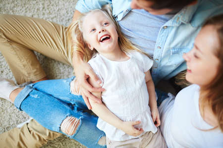Ecstatic girl and her parents enjoying weekend at home