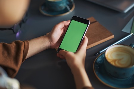 Person using smartphone, while he is resting in cafe