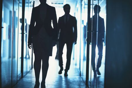 Office workers walking down corridor of business centerの写真素材