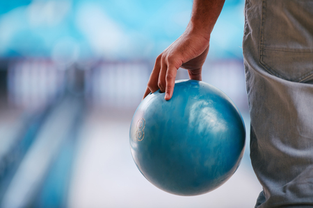 Young man in jeans holding bowling ballの写真素材