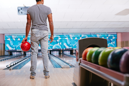 Young guy in casualwear playing bowlingの写真素材