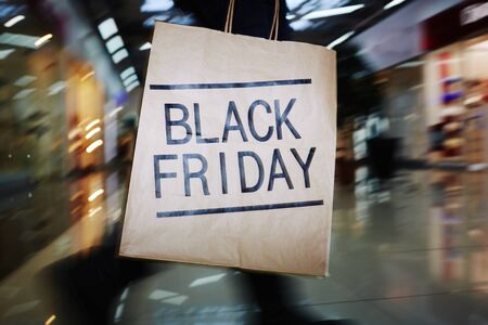 Shopaholic with Black Friday paperbag moving in the mallの写真素材