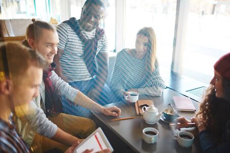 Group of multi-ethnic teenagers spending leisure in cafe
