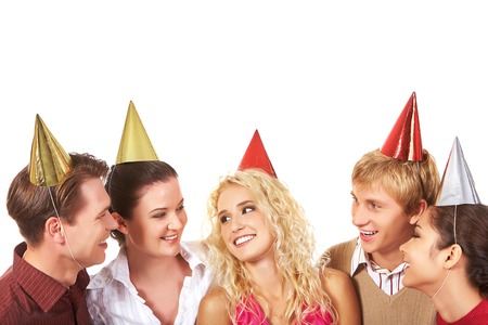 Happy friends in birthday caps talking to each otherの写真素材