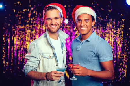 Handsome Santa guys with drinks having party in night clubの写真素材