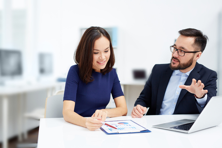 Two employees discussing document at meetingの写真素材