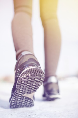 Close-up of female feet running on snowの写真素材
