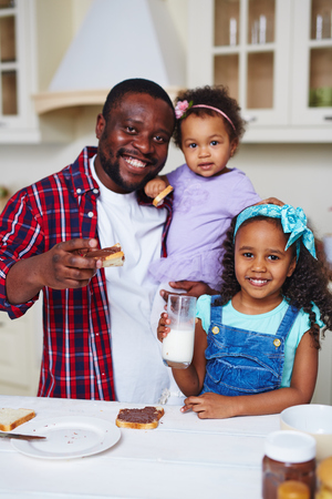 Happy African-American family having sandwiches for brunchの写真素材