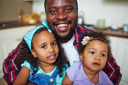 Happy African-American man and his two cute daughtersの写真素材