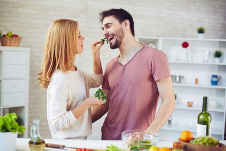 Young woman giving parsley leaf to her husbandの写真素材