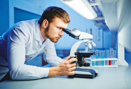 Modern scientist studying new virus in labの写真素材