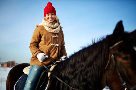Beautiful girl riding horse on hippodromeの写真素材