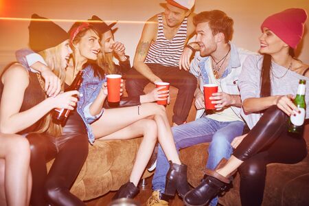 Happy young people with drinks relaxing in bar