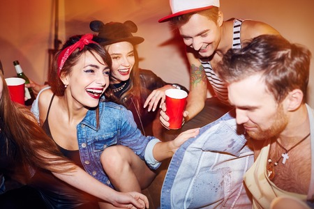 Happy young people in casual-wear relaxing in bar
