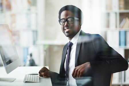 Elegant businessman sitting at workplace in office