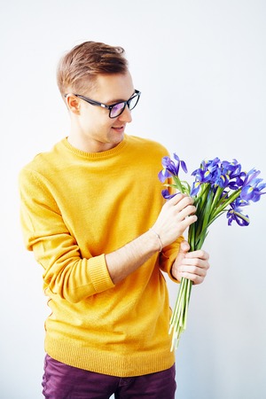 Handsome man holding bunch of fresh blue irisesの写真素材