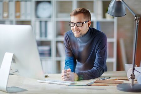 Young businessman looking at interesting data in internetの写真素材
