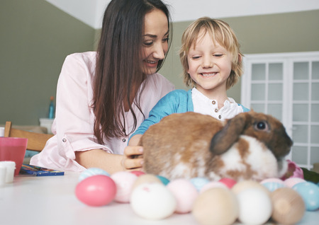 Happy young woman and her son playing with Easter rabbit