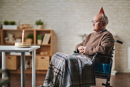 Senior man on wheelchair having birthdayの写真素材