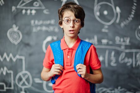 Amazed schoolboy in eyeglasses looking at cameraの写真素材