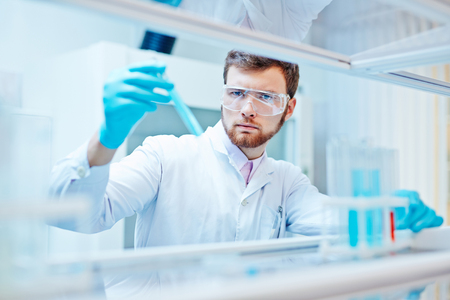 Young chemist studying fluid substance in labの写真素材