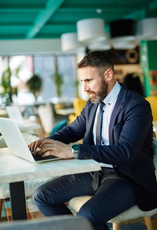 Contemporary businessman networking on laptopの写真素材